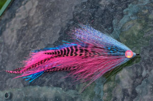 cotton candy colored muskie fly on wood