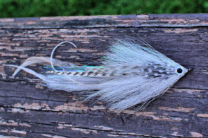 white minnow muskie fly on wood