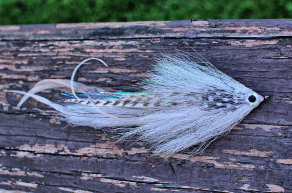 white minnow muskie fly on wood